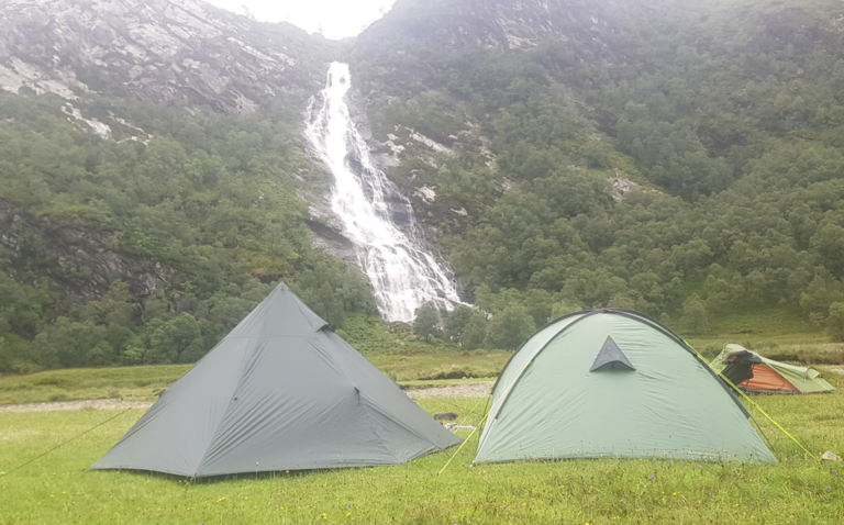 Camp set up near a massive waterfall