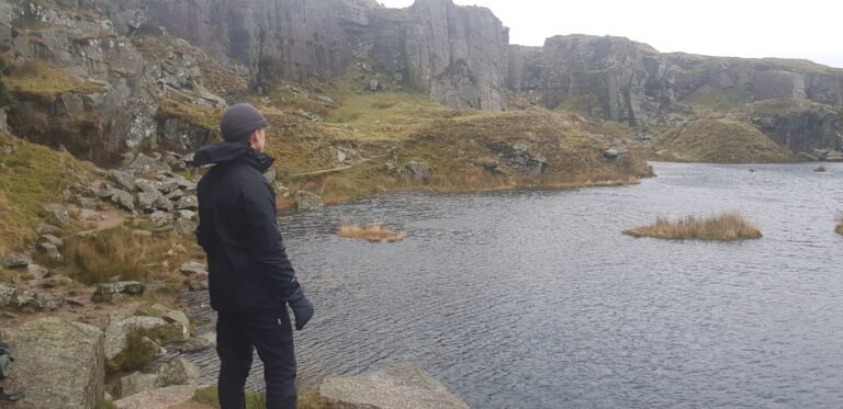 Man looking over a lake inside a quarry